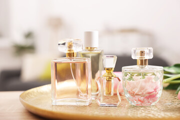 Bottles of aromatic perfume on table against blurred background, closeup