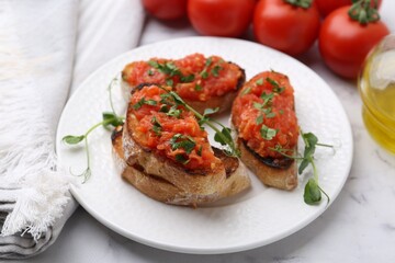 Tasty bread with tomatoes, parsley and oil on white marble table, closeup