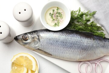 Salted herring and spices on white table, flat lay