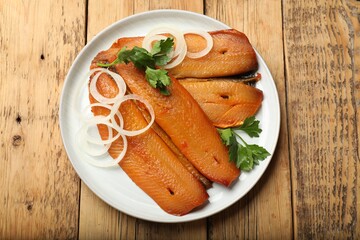 Smoked herrings, parsley and onion on wooden table, top view