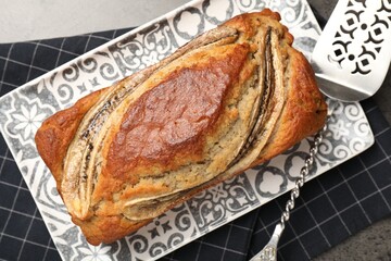 Delicious banana bread and server on grey table, top view