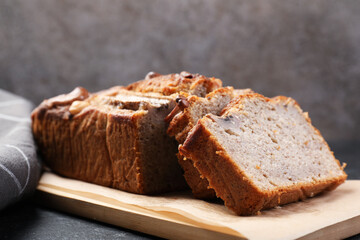 Cut banana bread with nuts on black table, closeup