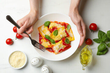 Woman eating delicious ravioli at white table, top view