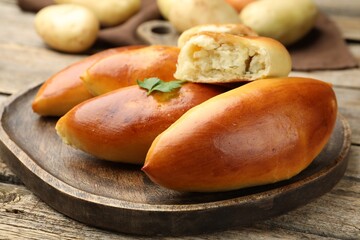 Tasty baked patties with potato and parsley on wooden table, closeup