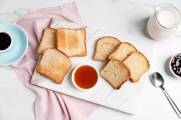 Slices of tasty toasted bread and jam on white marble table, flat lay