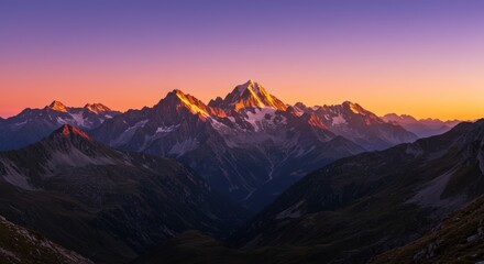 Obraz premium Mountain range at sunset with a vibrant purple and orange sky creating a stunning alpine landscape panorama view