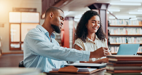 University, books and students in library on laptop for online research, information and studying for project. College, academy and man and woman on computer for education, knowledge and learning