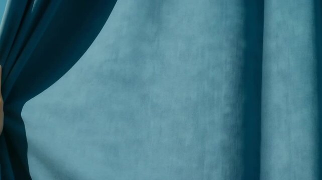 Human Hand Pulls Blue Curtain Smoothly Across Frame from Right to Left Until Fully Closed