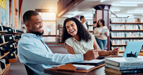 University, happy and students in library on laptop for online research, information and studying for project. College, academy and man and woman with books for education, knowledge and learning