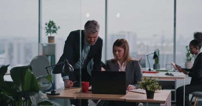 Couple of Male and Female Caucasian Executives Wearing Suits Talking about Business Idea Financial Report Agend Cooperating at Office.