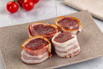 Raw pork tenferloin with bacon