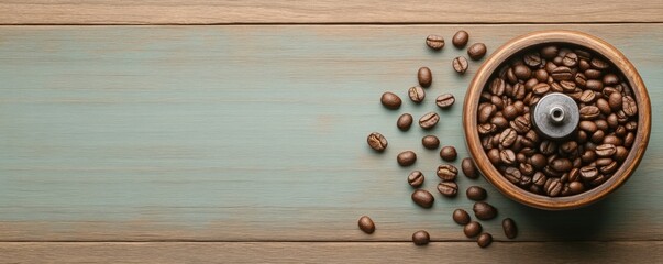 Fototapeta premium A wooden coffee grinder filled with aromatic coffee beans, surrounded by scattered beans on a rustic wooden surface.