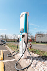 Modern electric vehicle charging station stands urban setting, representing the shift towards sustainable transport solutions