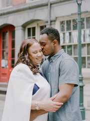 Romantic couple embraces in a charming urban setting during a sunny day in the city