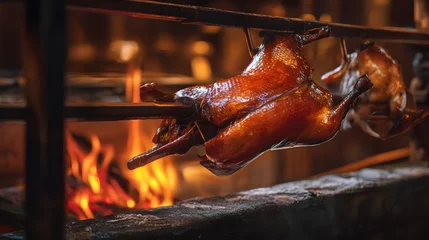 Fotobehang Peking Whole traditional Peking duck hanging and roasting on wood fire in a rustic kitchen setting  © Thisisbest