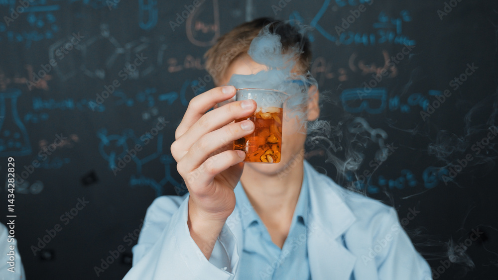 Poster closeup of boy inspect chemical solution while holding beaker at blackboard with chemical theory. sm