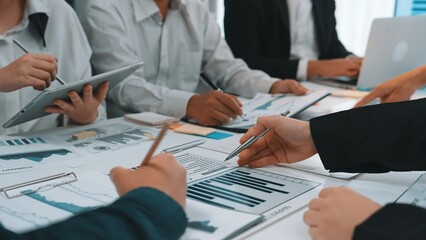 A diverse business team engaged in reviewing financial reports and data visualizations in a modern office. Collaboration and analysis drive insights for strategic decisions. SACTR