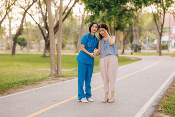 Fototapeta premium In the heart of a lush park, a caring young Asian female doctor guides her elderly patient through gentle exercises, embracing the refreshing, clean air together.