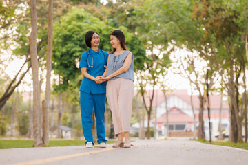Obraz premium In the heart of a lush park, a caring young Asian female doctor guides her elderly patient through gentle exercises, embracing the refreshing, clean air together.