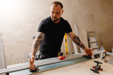 Craftsman working on ceramic tile using tile cutter in workshop