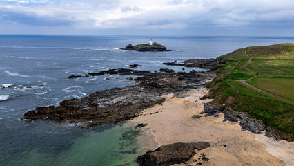 South England coastal drone footage with cliffs, rocky beach, green meadows, and a scenic island lighthouse. Perfect for stock video, tourism promotions, and nature projects.