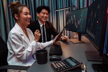 Businesswoman holding tablet on dynamic stock exchange statistic online showing to partners to...