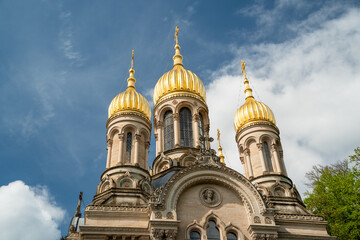 Russian Orthodox church with golden domes in the German city of Wiesbaden. Against the blue sky with clouds