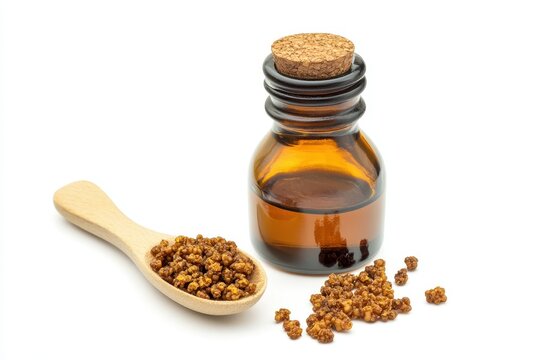 A container of propolis extract and a wooden spoon of granules Bee products for medical use Isolated on a white surface