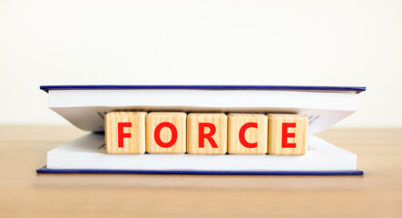 Force symbol. Concept word Force on beautiful wooden blocks in book. Beautiful wooden table white...