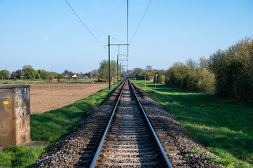 Single railway track through agriculture fields at the Flemish countryside in Hollebeke, Ieper,...