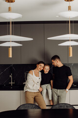 Happy family posing in modern kitchen with designer lamps