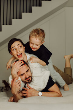 Happy family playing together on bed at home
