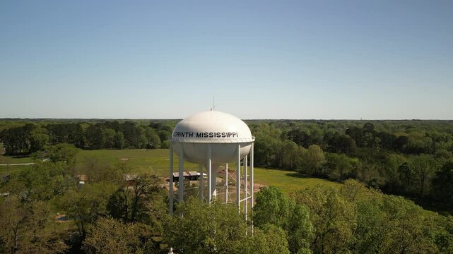 Aerial close up panning of Corinthe Mississippi water tower in springtime  in grassy fields