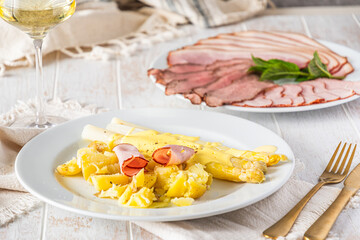 Plate with asparagus, potatoes, ham and hollandaise sauce