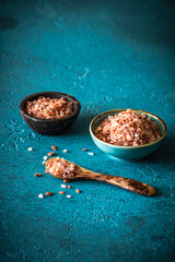 Himalayan salt in small bowls on blue background