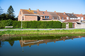 Obraz premium Colorful reflections of residential houses in the Comines - Ypres canal in Ieper, West Flanders, Belgium
