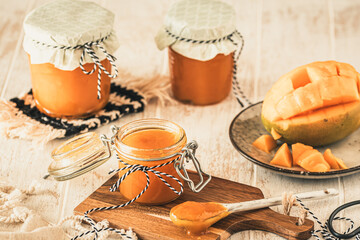 Homemade mango jam on white wooden table