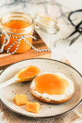 Bun with homemade mango jam on white wooden table