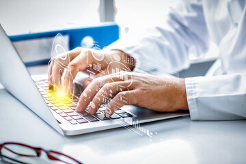 Male doctor working with laptop at table in clinic, closeup
