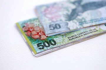 Argentine pesos money bills in big amount lies on white table close up