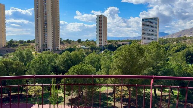 A stunningly beautiful landscape view showcasing lush greenery alongside modern architecture beneath a bright blue sky
