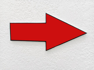 A bright red arrow points to the right on a textured white wall, indicating directions and navigation within the office space.