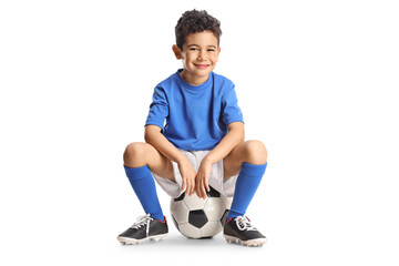 Asian boy sitting on a football and smiling