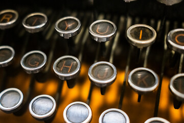 Close-up of vintage typewriter keys with a warm, nostalgic glow, capturing the essence of retro writing tools. Ideal for themes of history, creativity, or classic literature
