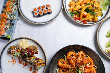 Variety of fresh sushi, noodles, and Asian dishes with copy space