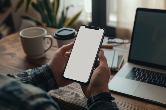 Latin indian adult student holding using mock up of cell mobile smartphone with empty blank white screen for advertising. Over shoulder closeup view.