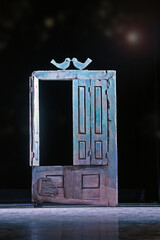 Vintage wooden rough blue door with peeled paint on dark background.