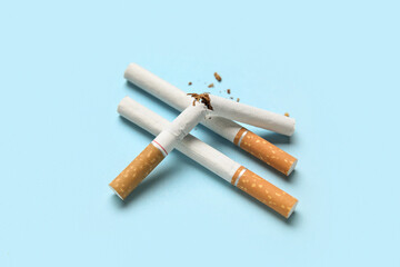 Broken and whole cigarettes on color background. No Tobacco Day concept