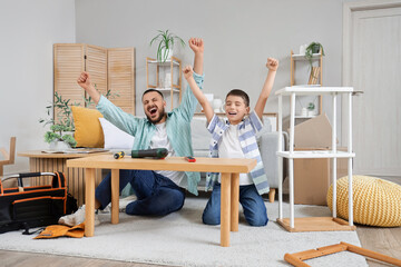 Happy father with his son assembling wooden bench at home