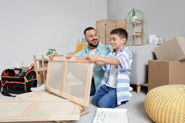 Father with his son assembling folding screen at home